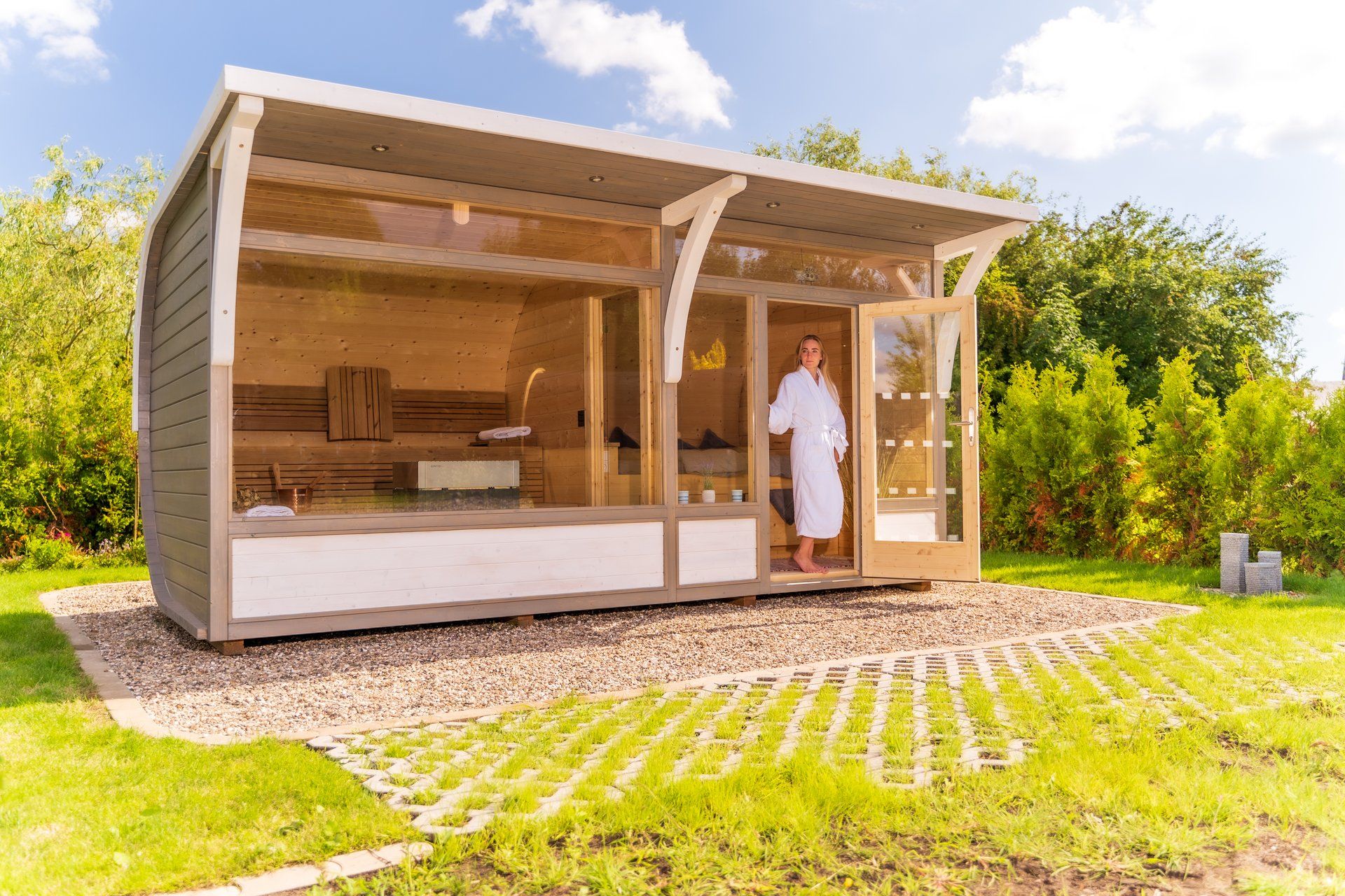 Frau im Bademantel vor moderner Design-Gartensauna – bretterkiste